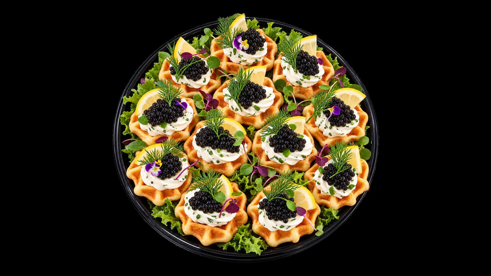 Waffle canapés topped with black caviar, cream cheese, lemon and fresh herbs